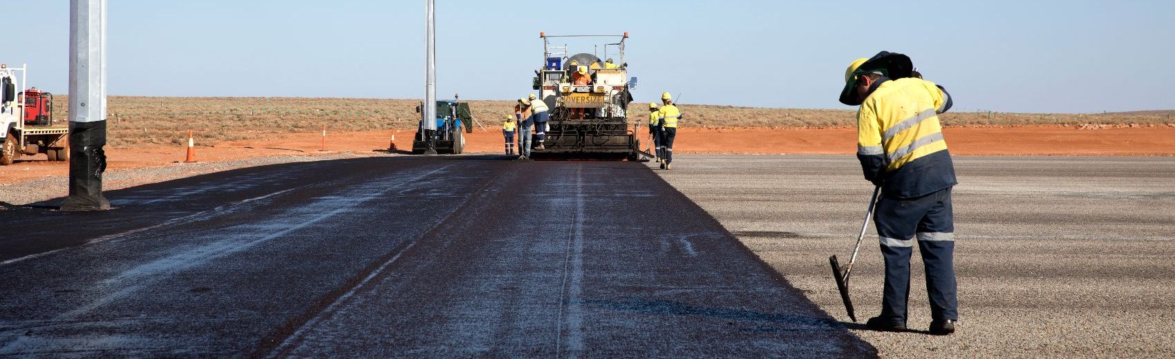 Road workers and machinery laying Downer Group's Bituminous products
